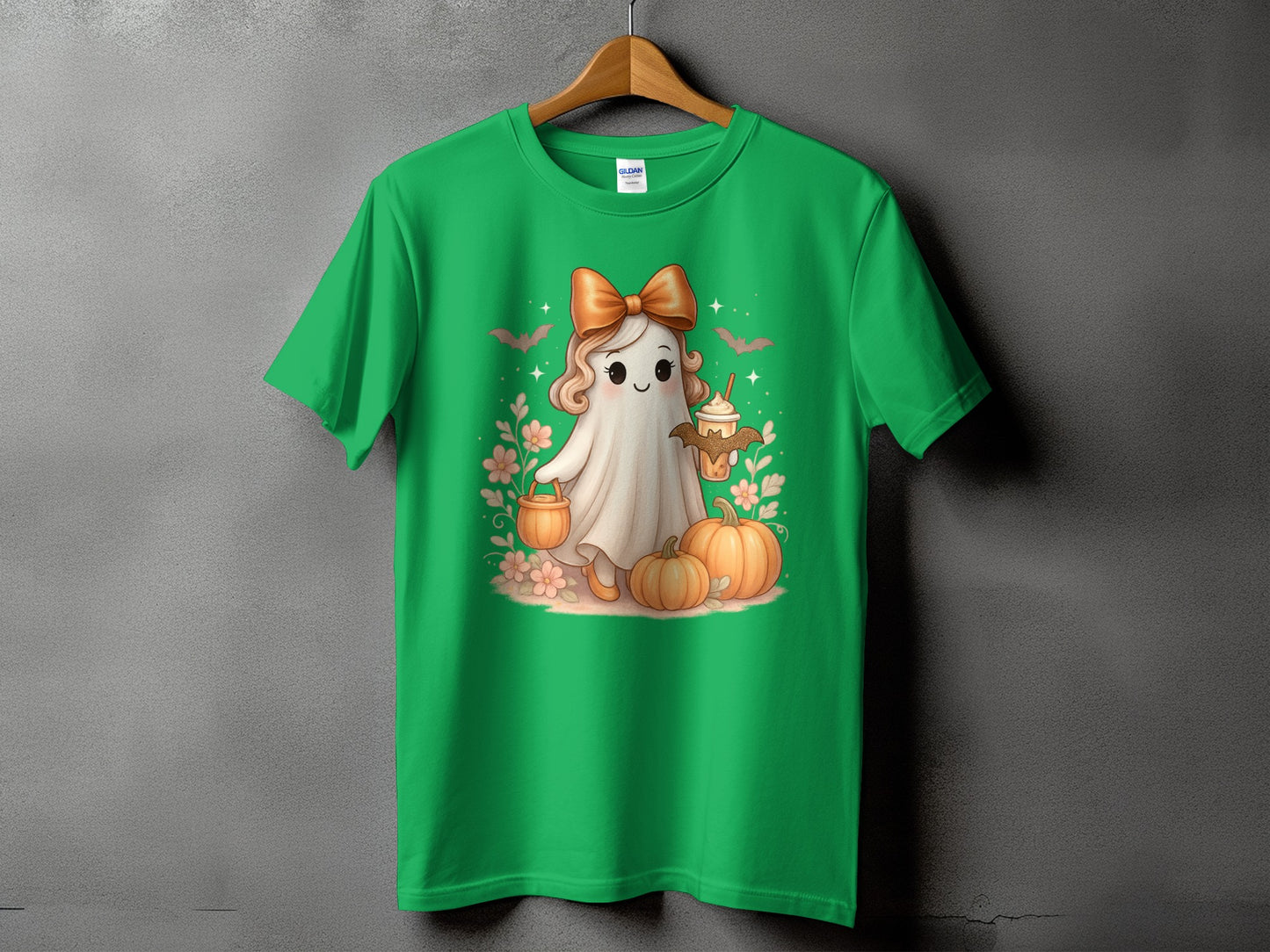 Green t-shirt with a cute ghost character holding a drink and surrounded by pumpkins.