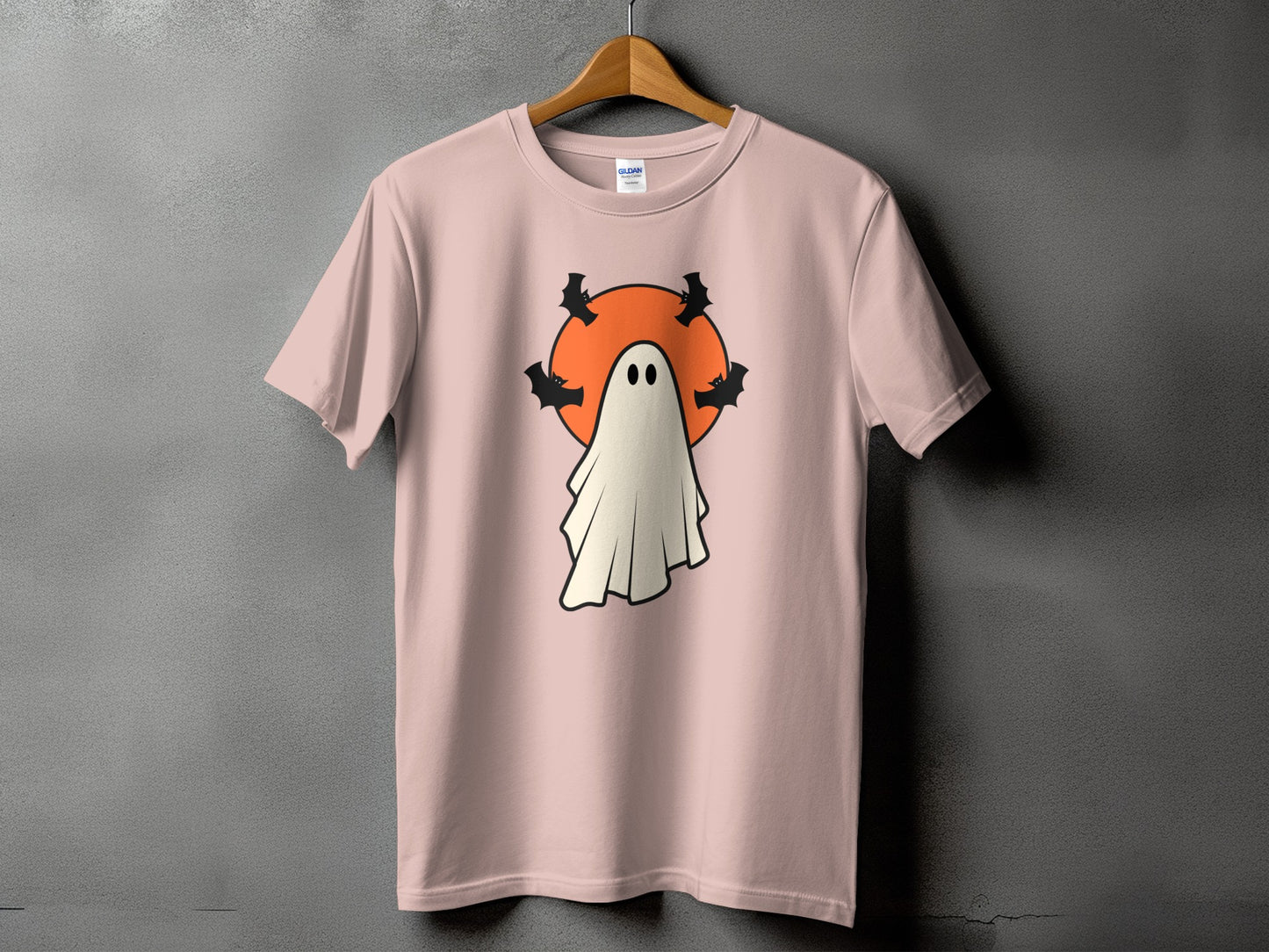 Pink t-shirt with a ghost, moon, and bat graphic.
