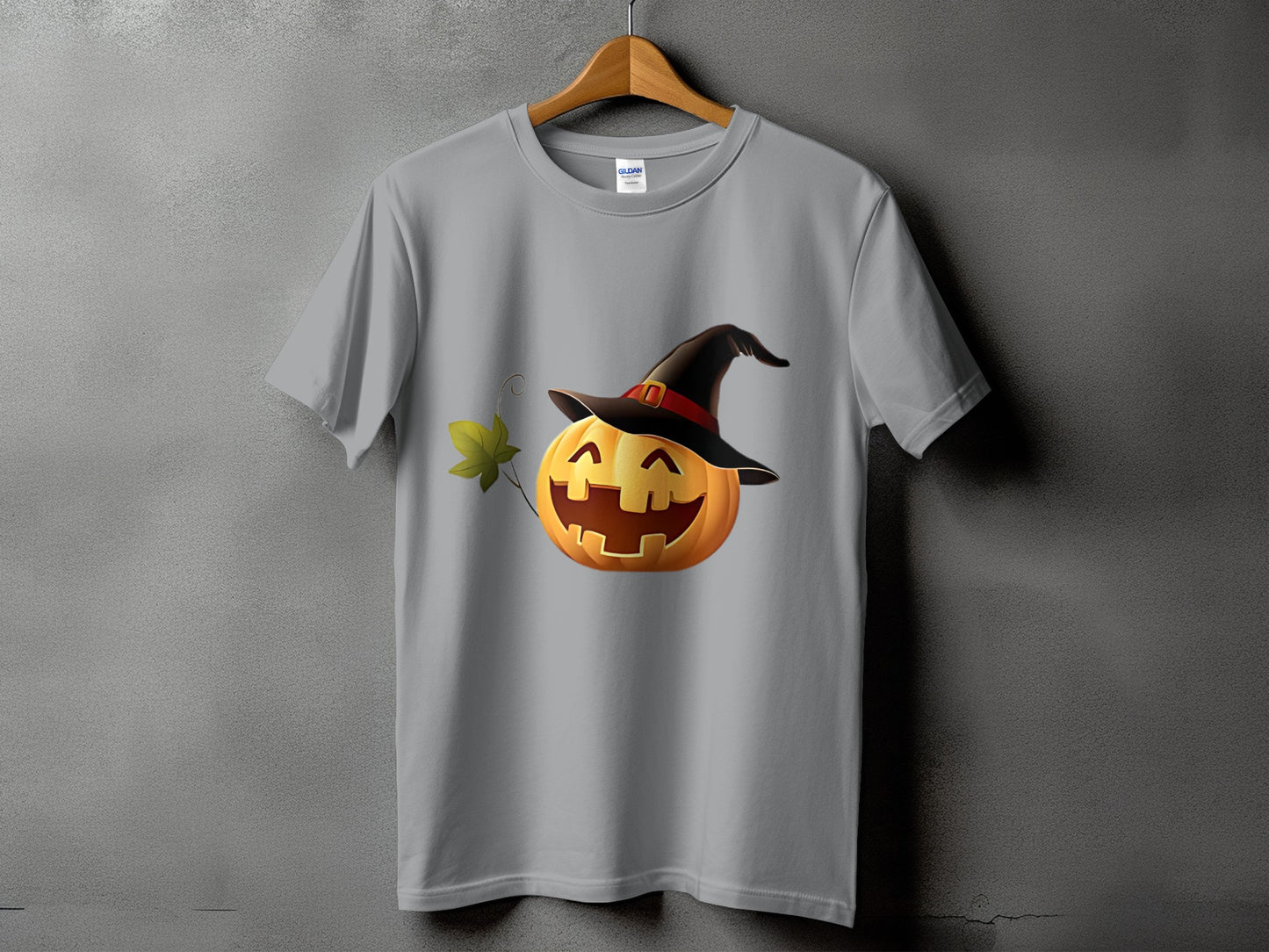 Grey t-shirt with a smiling pumpkin wearing a witch hat and a green leaf.