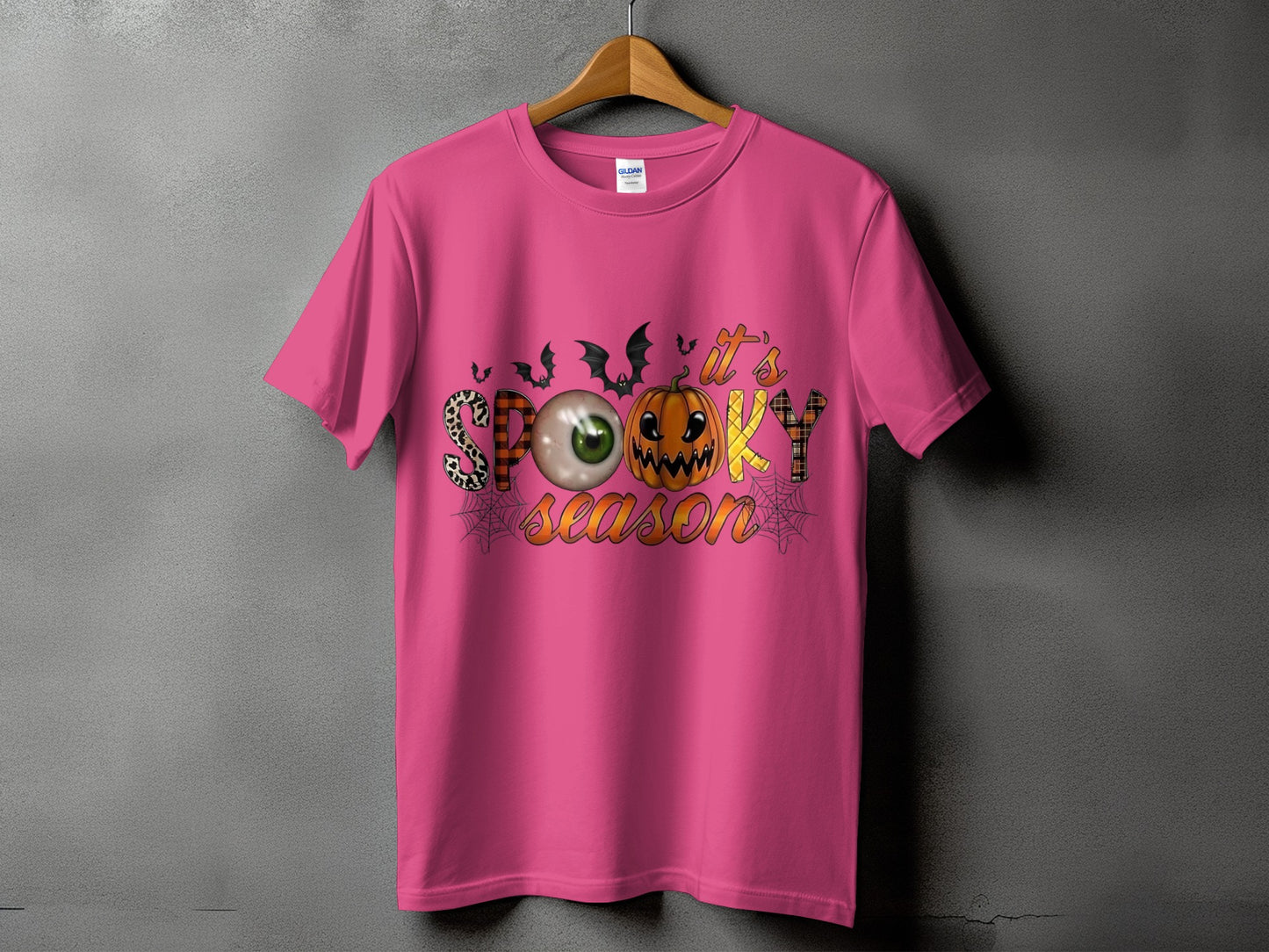 Pink t-shirt with "It's Spooky Season" Halloween graphic featuring a pumpkin and eyeball.