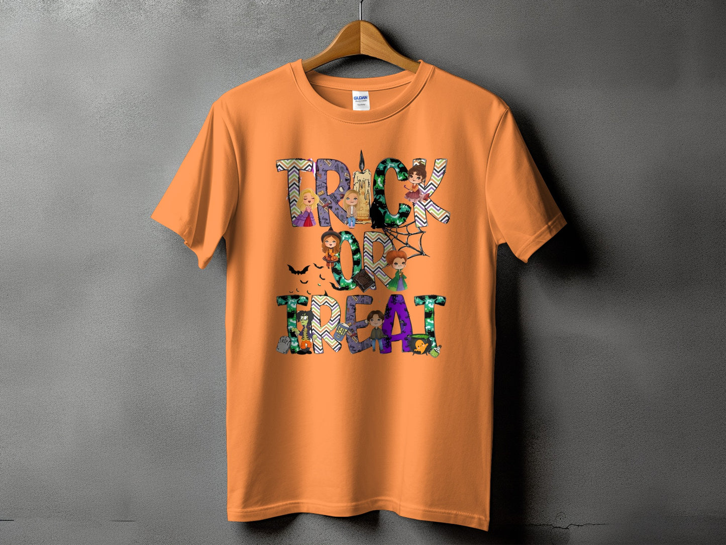 Orange t-shirt with "Trick or Treat" Halloween graphic featuring cartoon witches and candy.