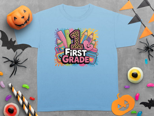 Light blue t-shirt with "1st GRADE" graphic featuring school supplies and a leopard print "1".