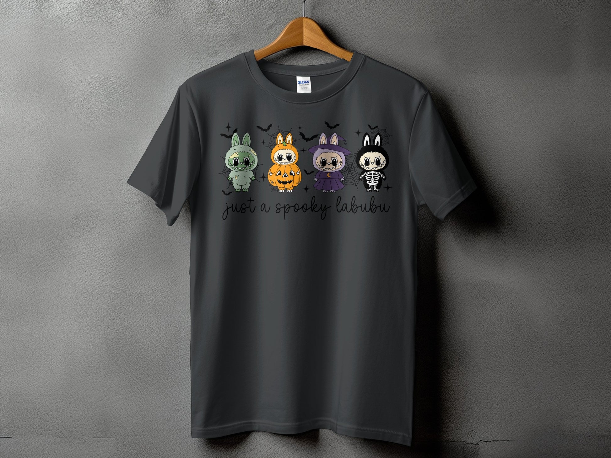Dark grey t-shirt with four spooky Halloween-themed cartoon characters and "just a spooky labubu" text.