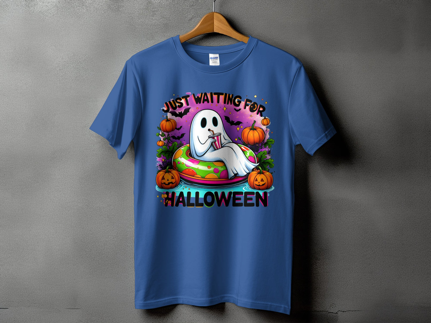 Ghost in inner tube with pumpkins and bats, reads "Just Waiting For Halloween."