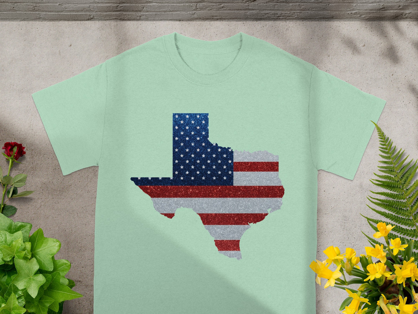 Pale green t-shirt with Texas outline filled with American flag glitter pattern.