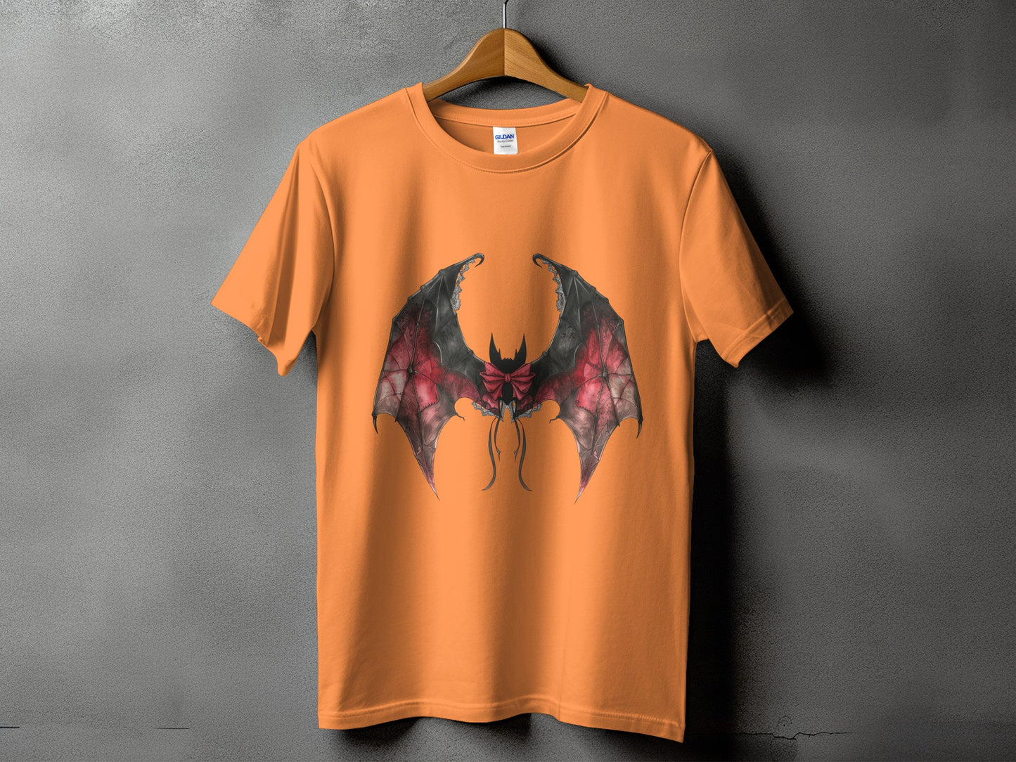 Orange t-shirt with a black and red bat wing graphic and bow detail.