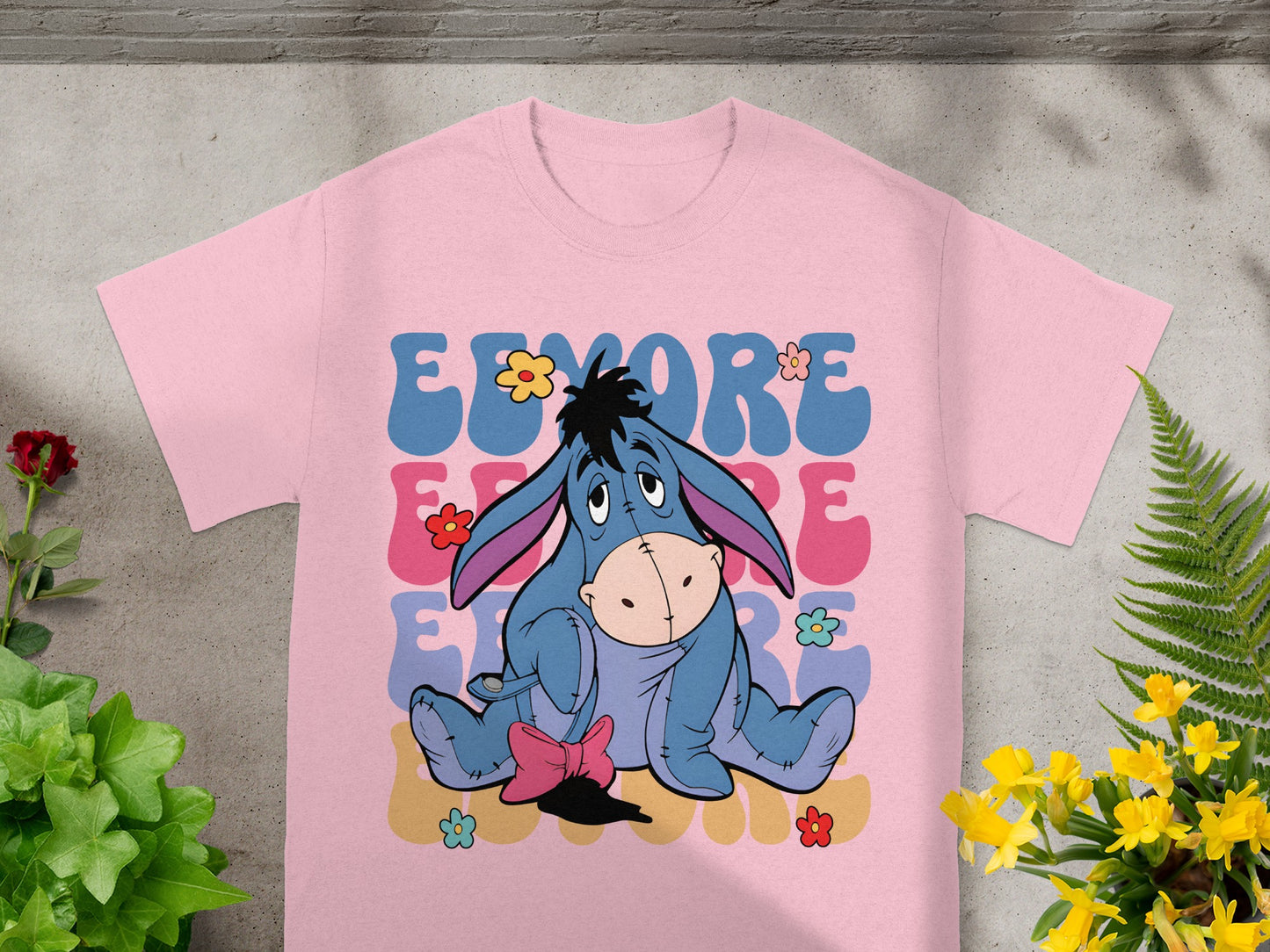 Pink t-shirt with Eeyore graphic and colorful "EEYORE" text.