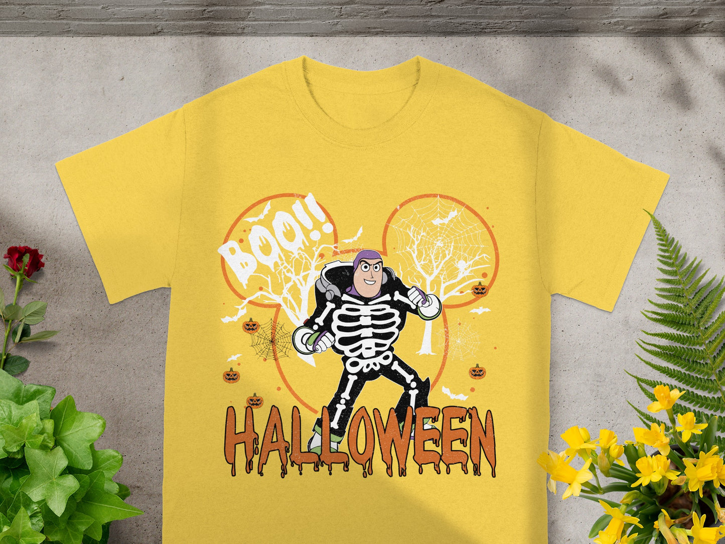 Yellow t-shirt with Buzz Lightyear in skeleton costume, "BOO!!" and "HALLOWEEN" text.