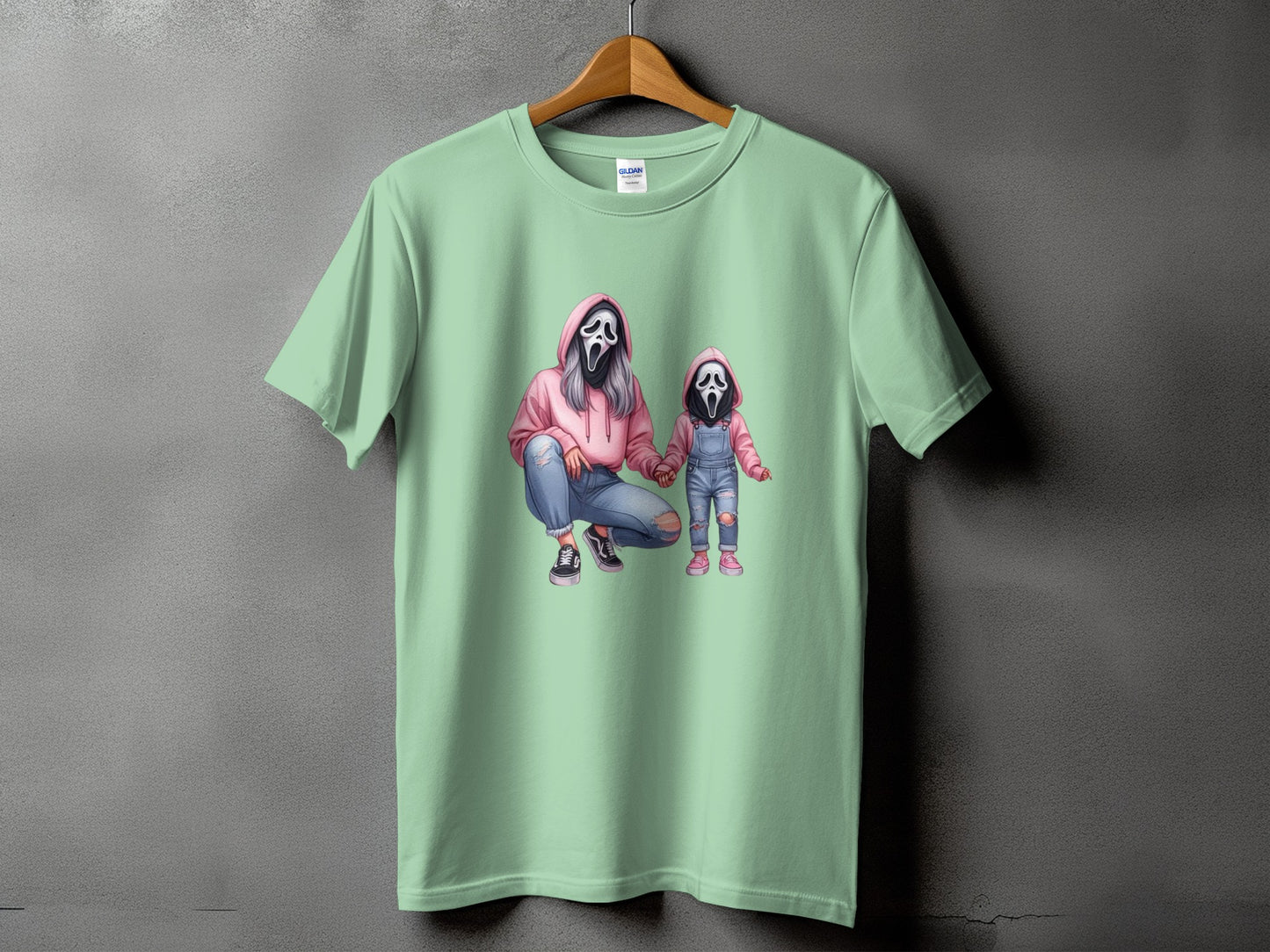 Mint green t-shirt with graphic of figures in Ghostface masks, one crouching, one standing.