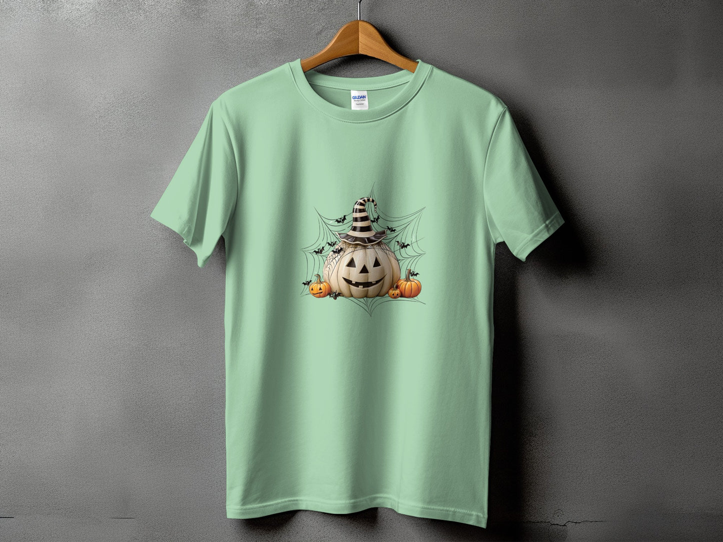 Light green t-shirt with a Halloween pumpkin design featuring spiders and bats.