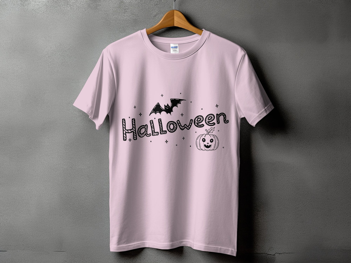 Pink t-shirt with black Halloween text, bat, and pumpkin graphic.