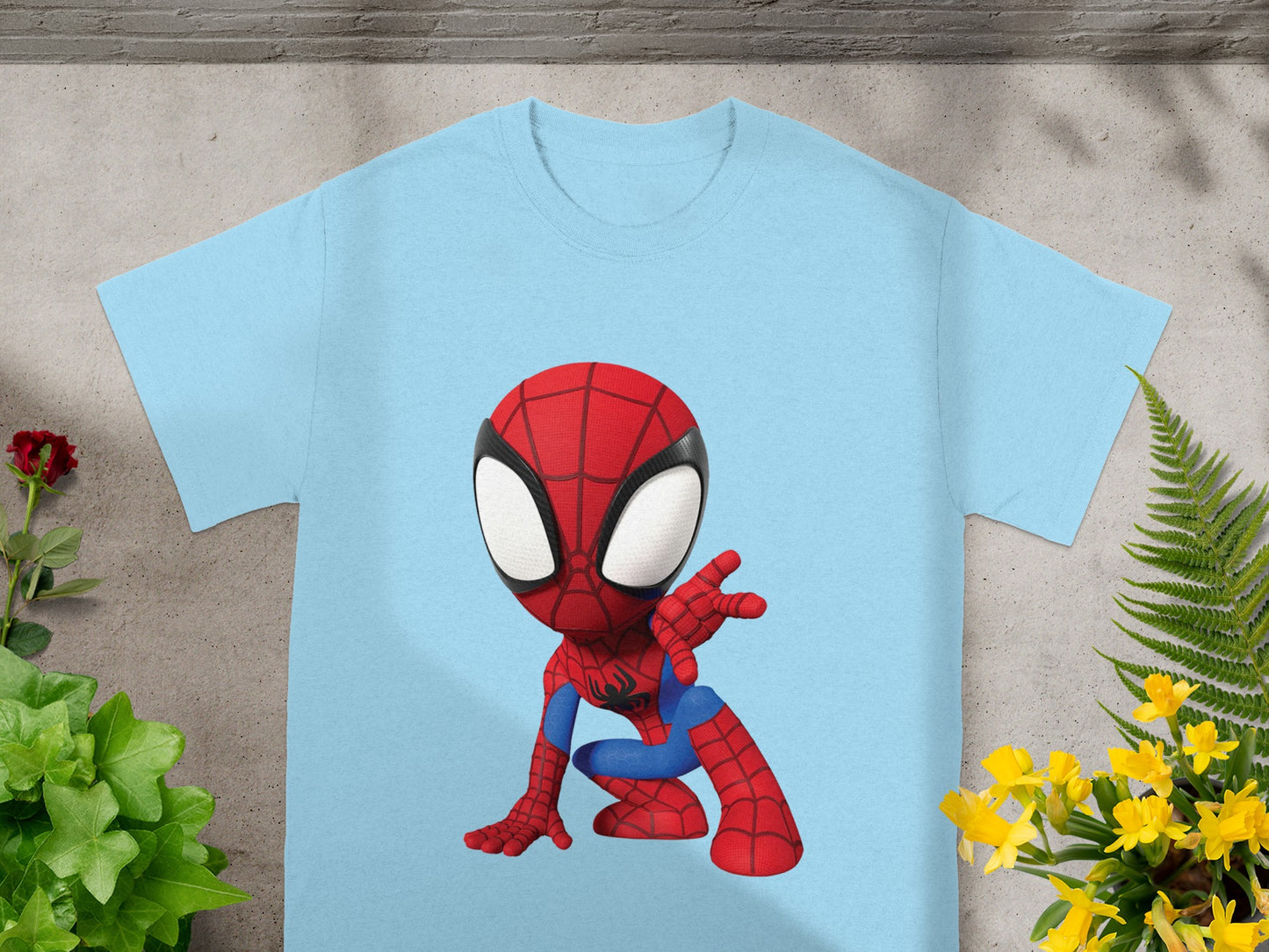 Light blue t-shirt with a cartoon Spiderman graphic in a crouching pose.