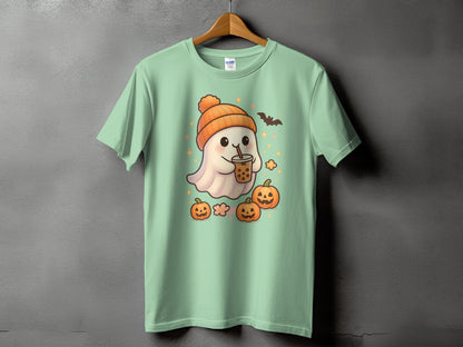 Mint green t-shirt with a cartoon ghost holding a bubble tea, wearing an orange hat, surrounded by pumpkins.