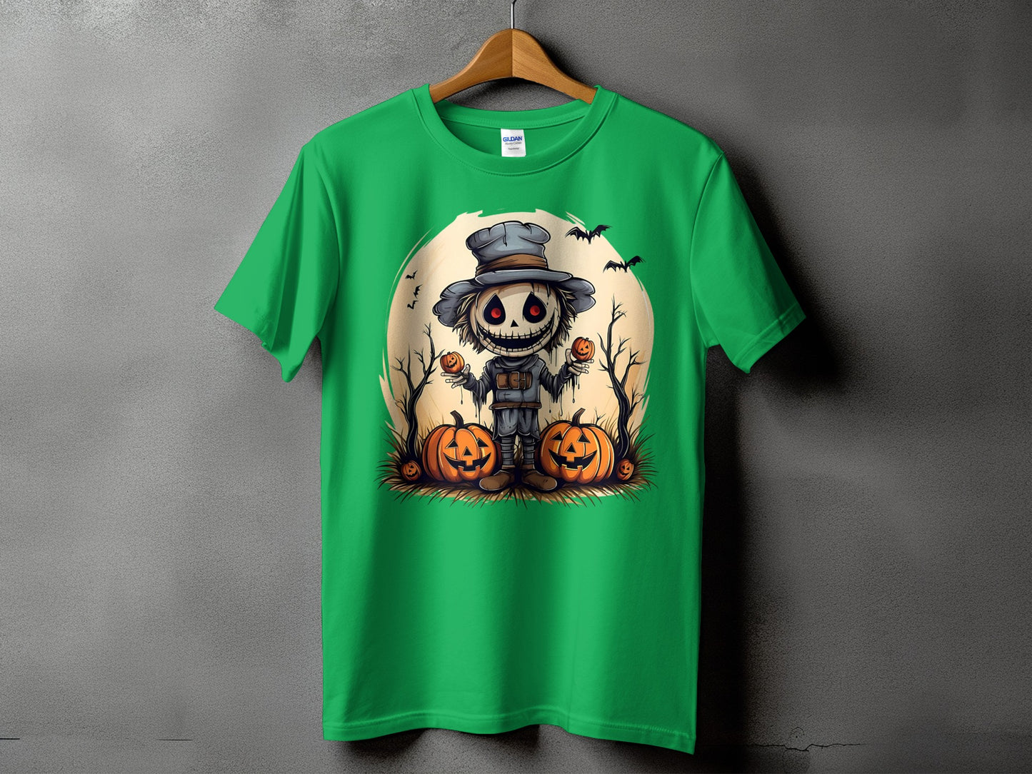 Green t-shirt with a Halloween scarecrow holding pumpkins and bats on a full moon background.