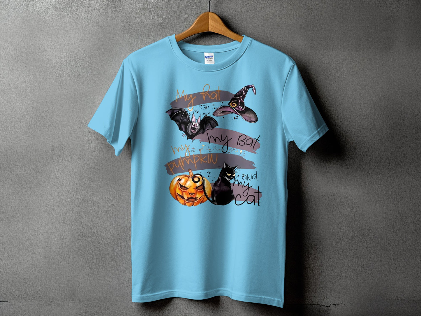 Light blue t-shirt with Halloween graphic: bat, witch hat, pumpkin, and cat.
