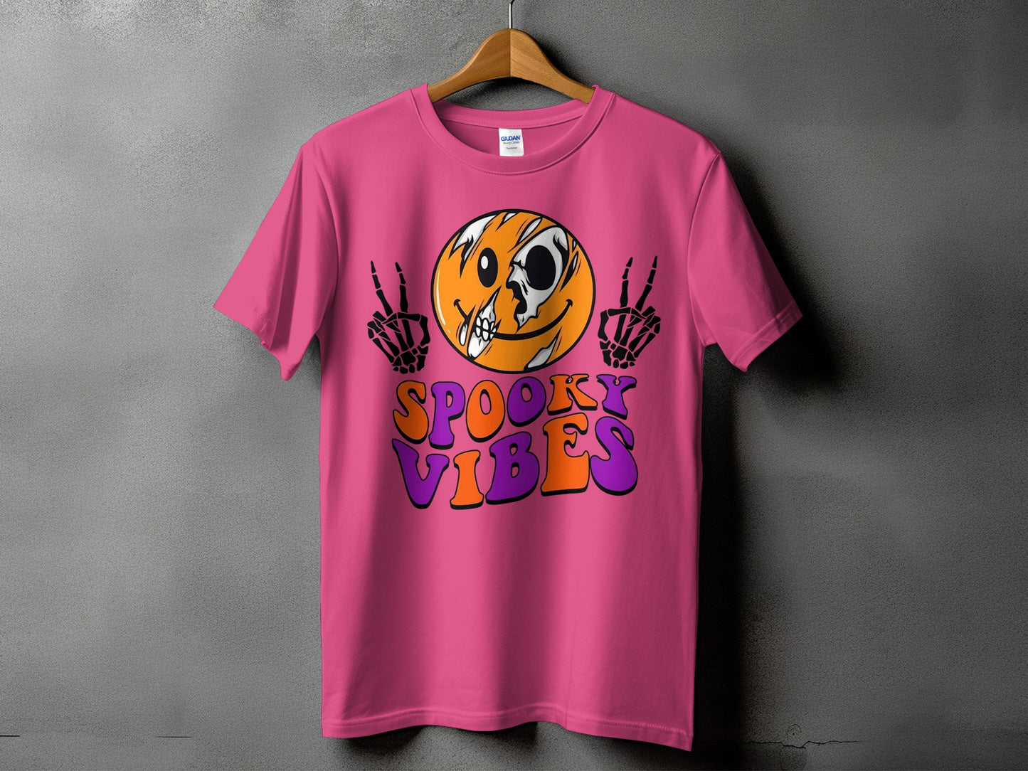 Pink t-shirt with spooky skeleton hands, skull-face smiley, and "Spooky Vibes" text.