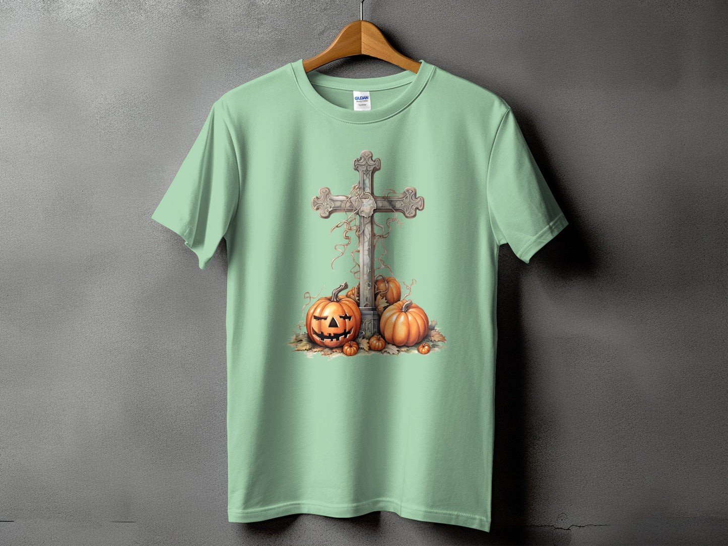Light green t-shirt with a stone cross and pumpkins graphic.