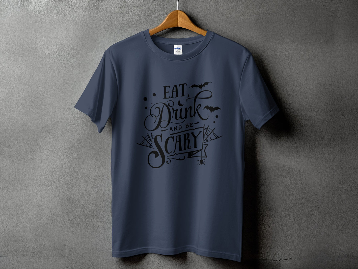 Dark blue t-shirt with black text reading "Eat, Drink and be Scary" and Halloween graphics.