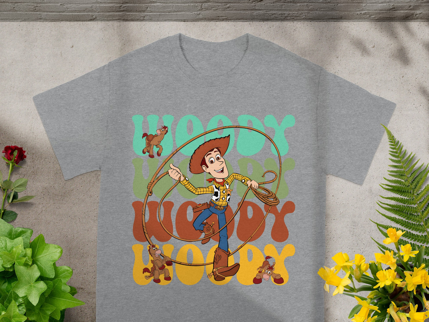 Woody character from Toy Story with Lasso and "WOODY" text on gray t-shirt.