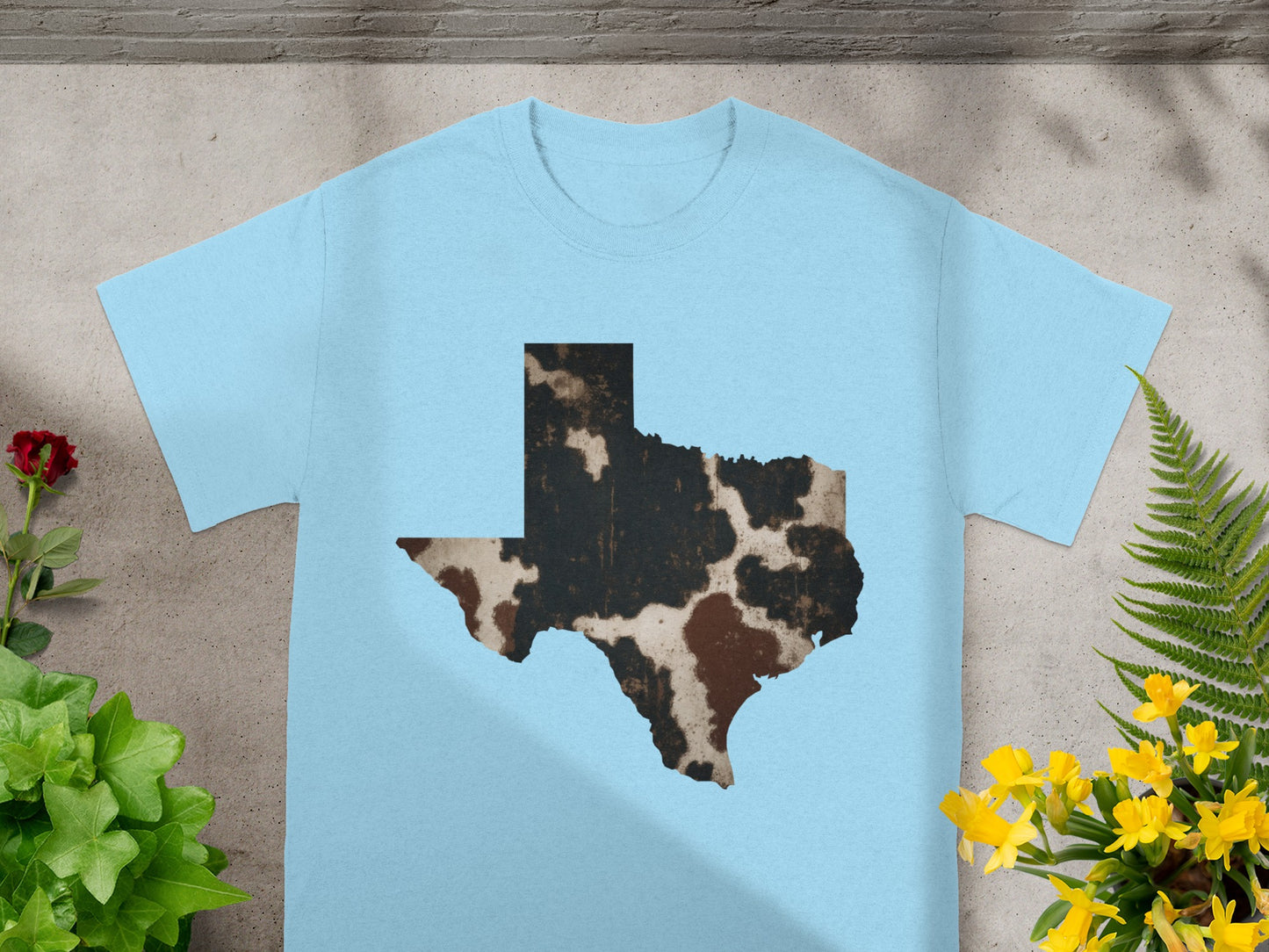 Light blue t-shirt with a Texas map outline in cow print.