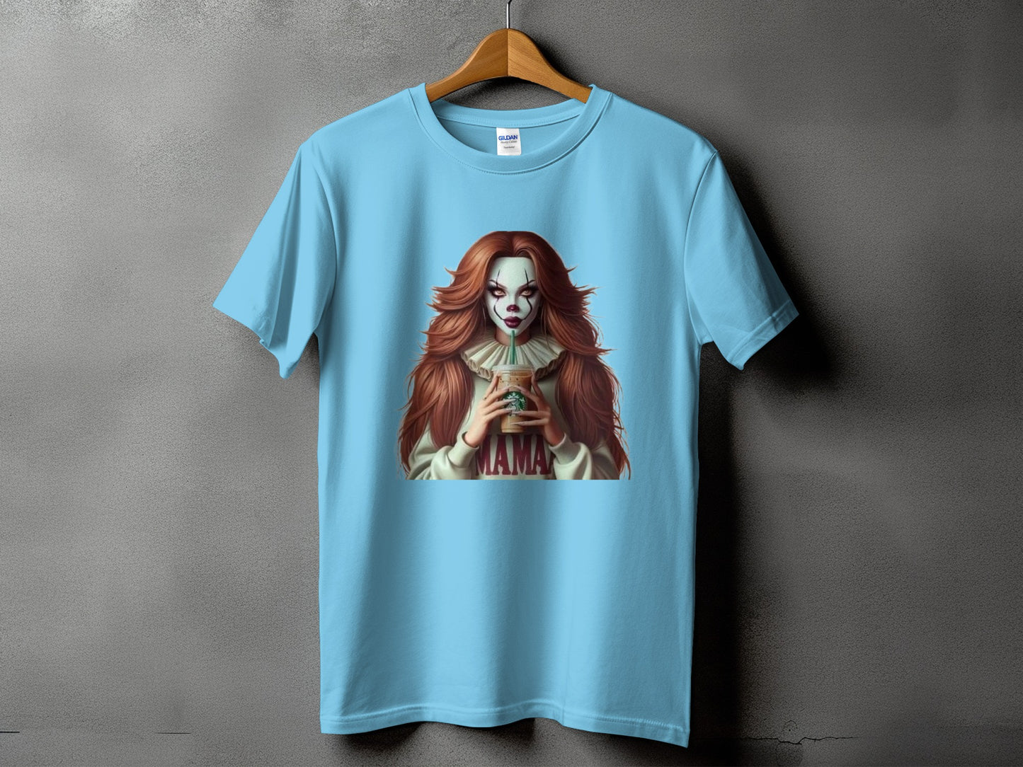 Light blue t-shirt with clown graphic holding a coffee cup, text "MAMA".