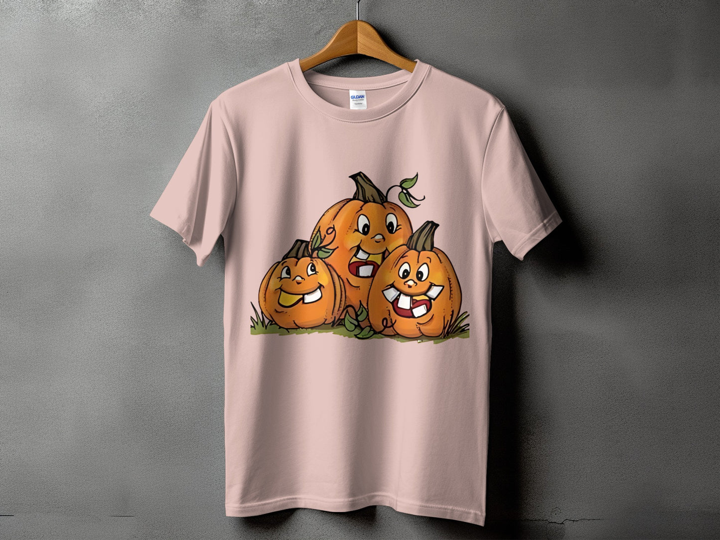 Pink t-shirt with cartoon pumpkins smiling and showing teeth.