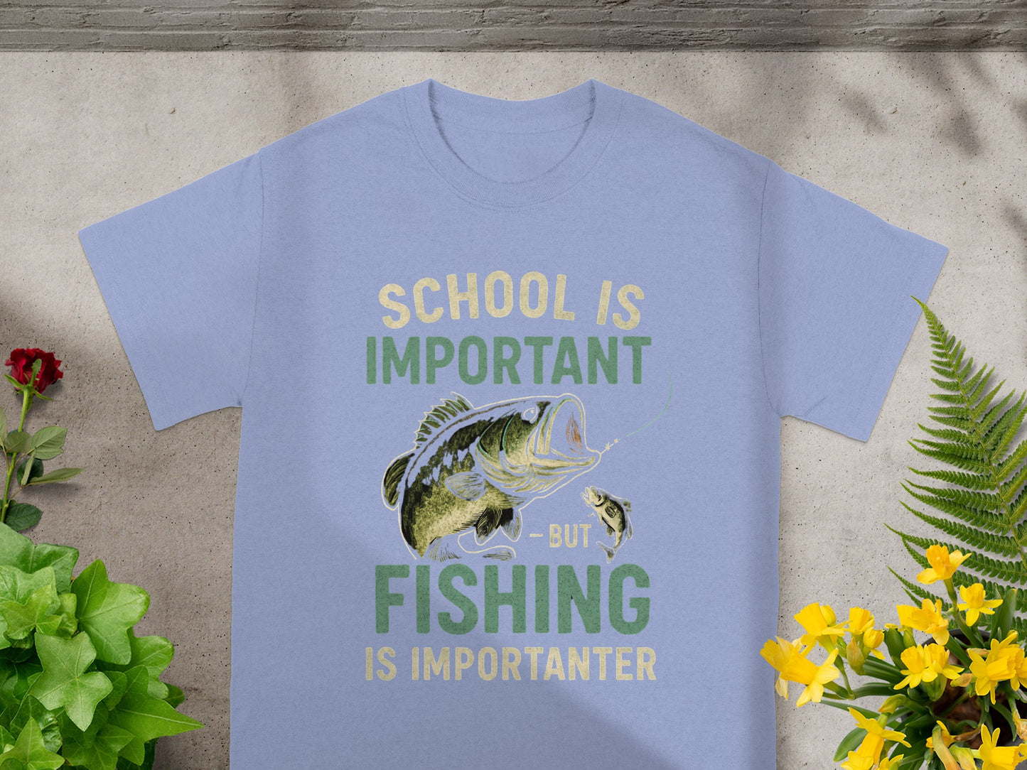 Light blue t-shirt with graphic of bass fishing and text "School is important but fishing is importanter".