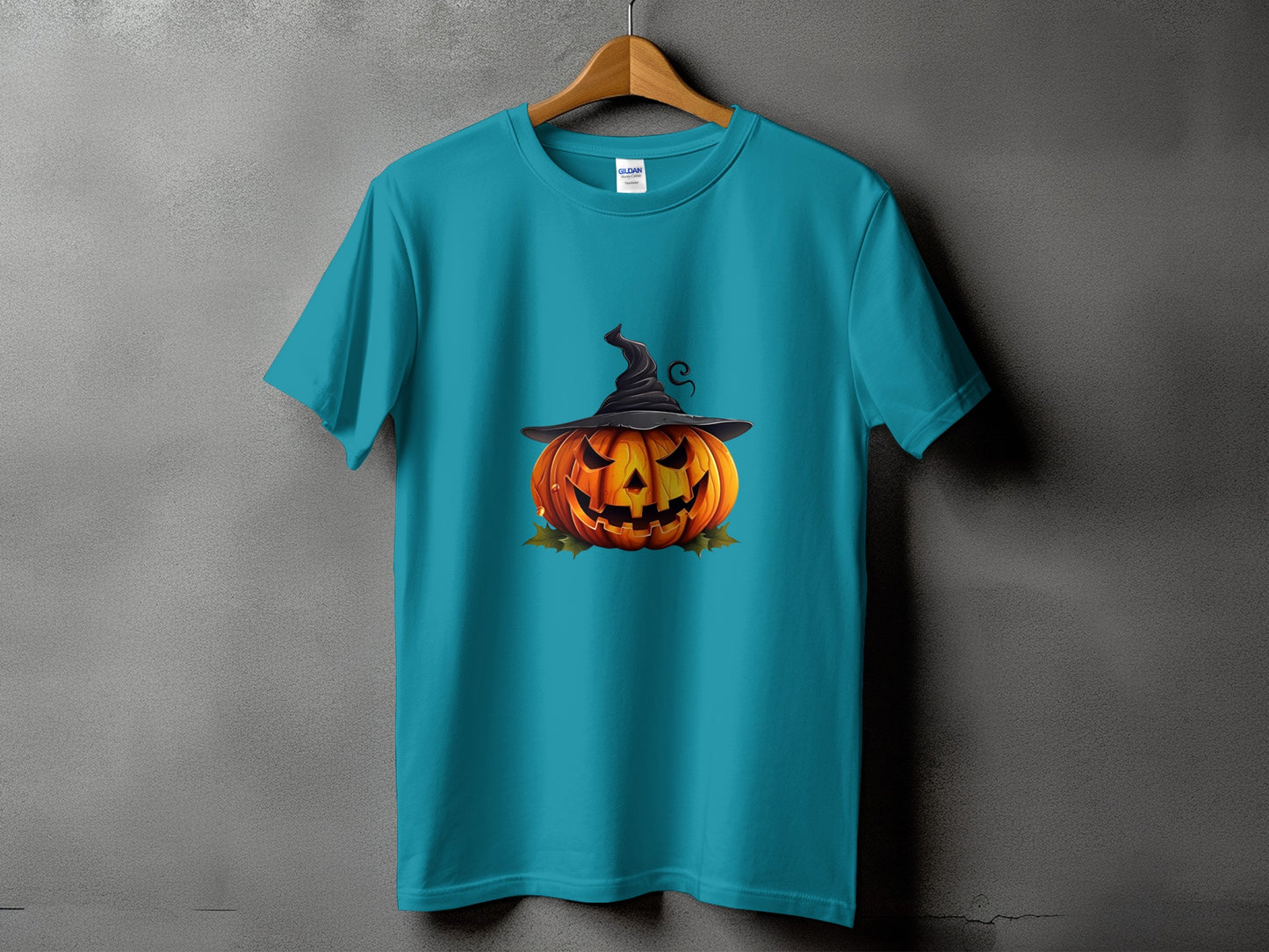 Teal t-shirt featuring a Jack-o'-lantern wearing a witch hat and surrounded by leaves.