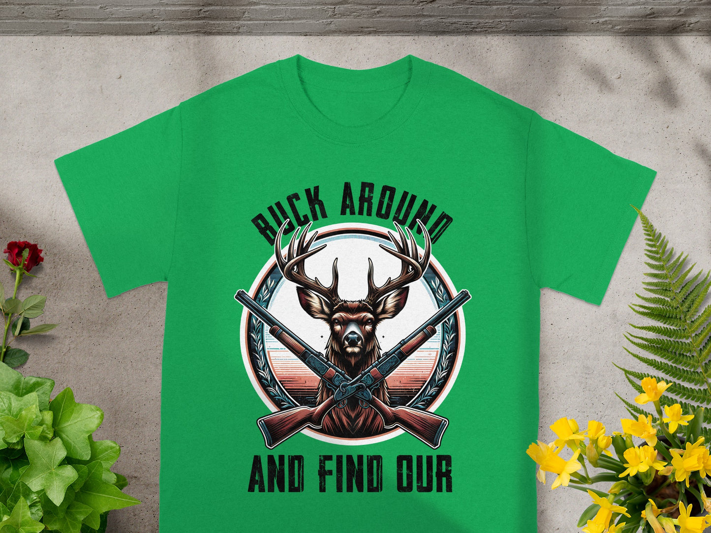Green t-shirt with deer head, crossed shotguns, and text "BUCK AROUND AND FIND OUR".
