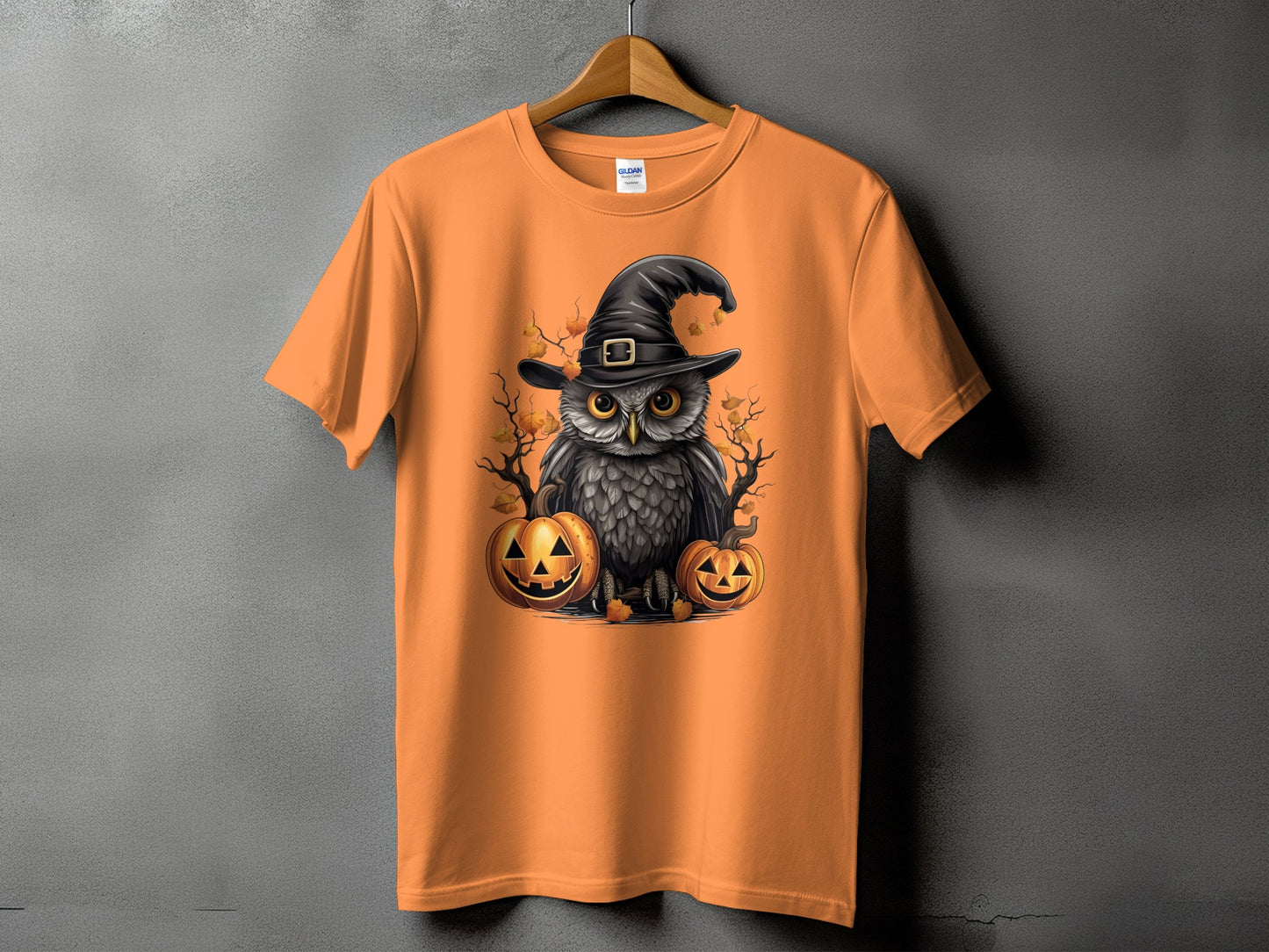 Orange t-shirt with a witch hat owl and two jack-o'-lanterns.