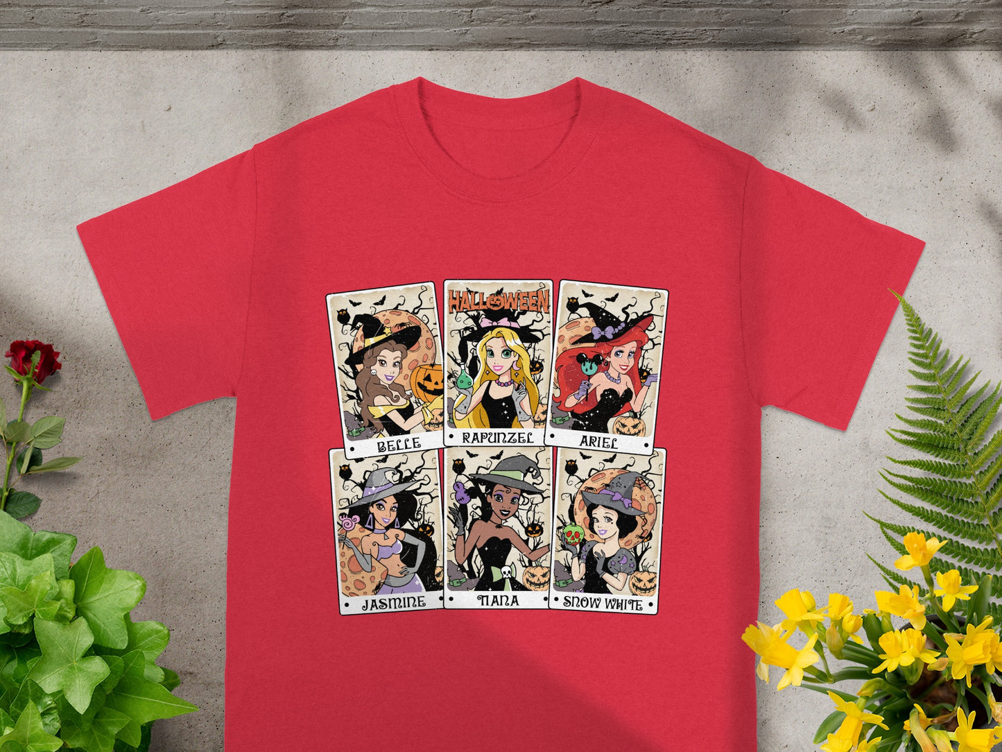 Red t-shirt with six Halloween-themed princess illustrations labeled Belle, Rapunzel, Ariel, Jasmine, Tiana, and Snow White.