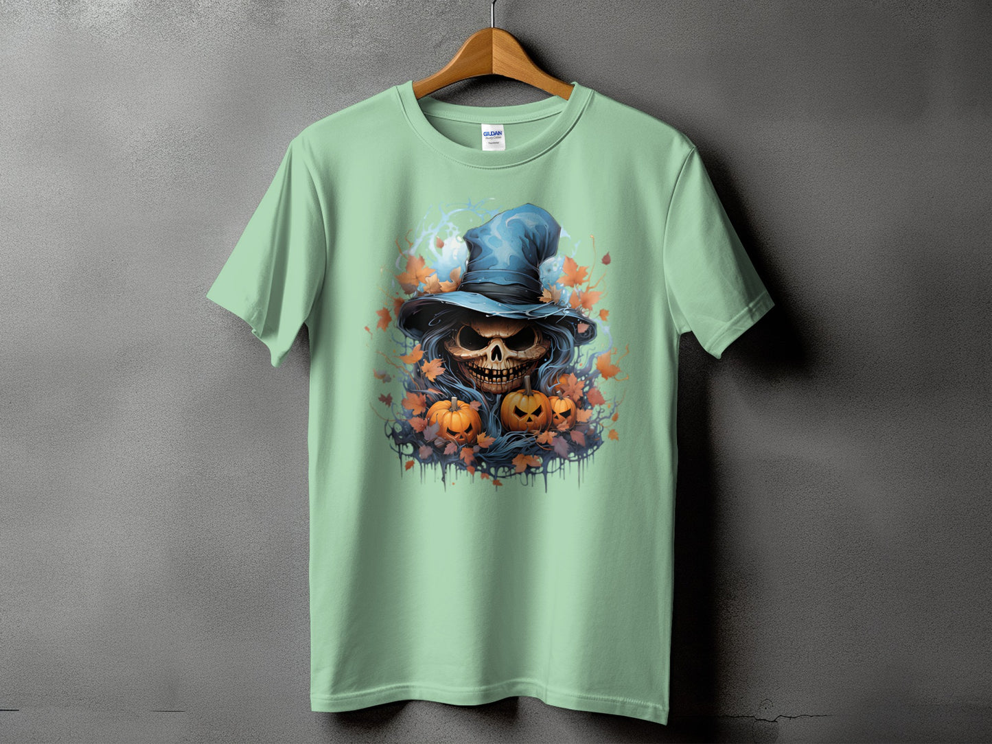 Mint green t-shirt with Halloween skull, pumpkins, and autumn leaves graphic.