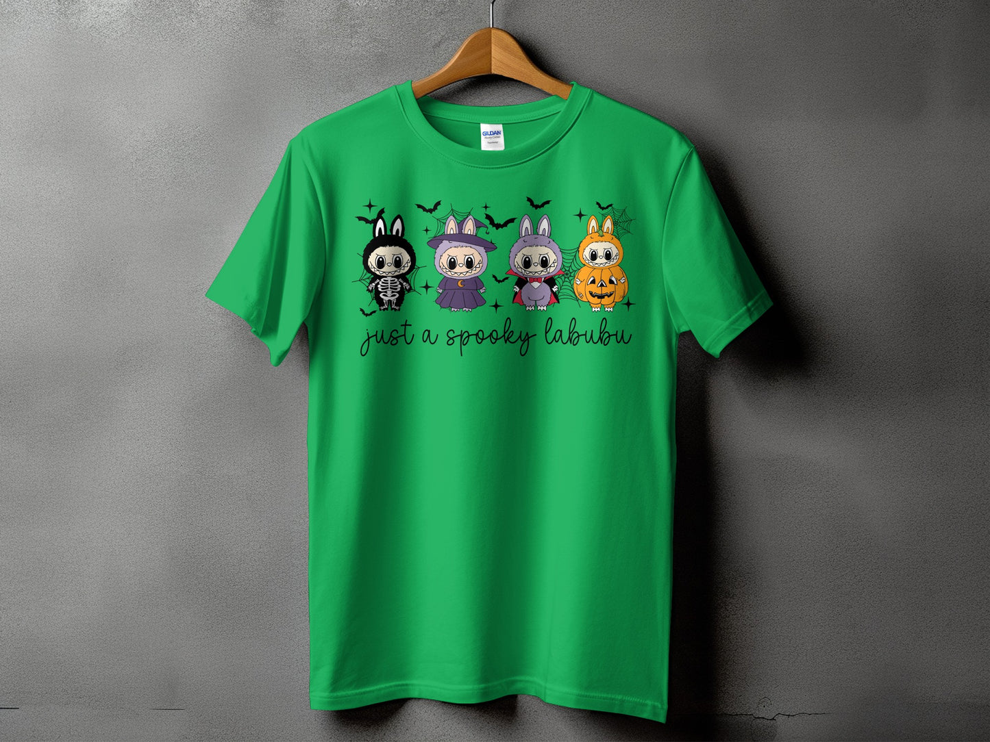 Green t-shirt with four cute Halloween characters and "just a spooky labubu" text.