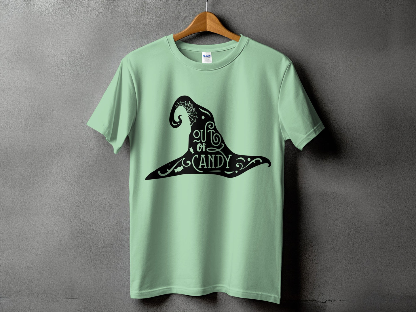 Light green t-shirt with black witch hat graphic and "out of candy" text.