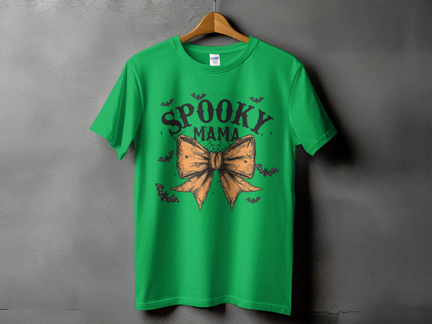 Green t-shirt with "Spooky Mama" text, bow, and bats graphic.