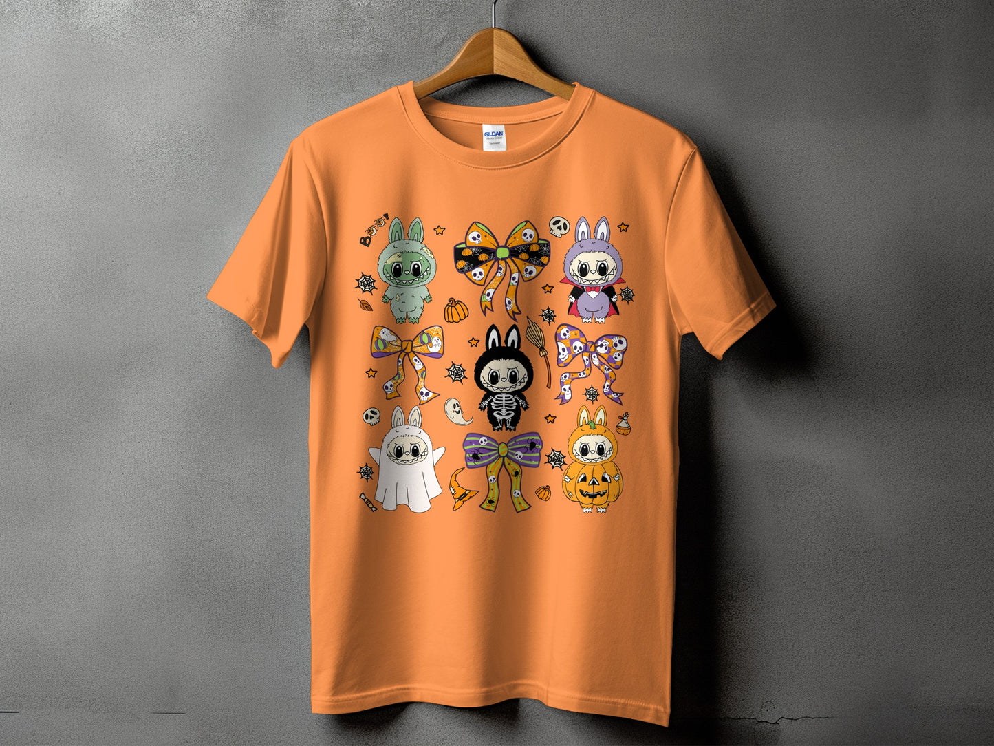 Orange t-shirt with cartoon Halloween bunnies dressed as a ghost, skeleton, vampire, and pumpkin.
