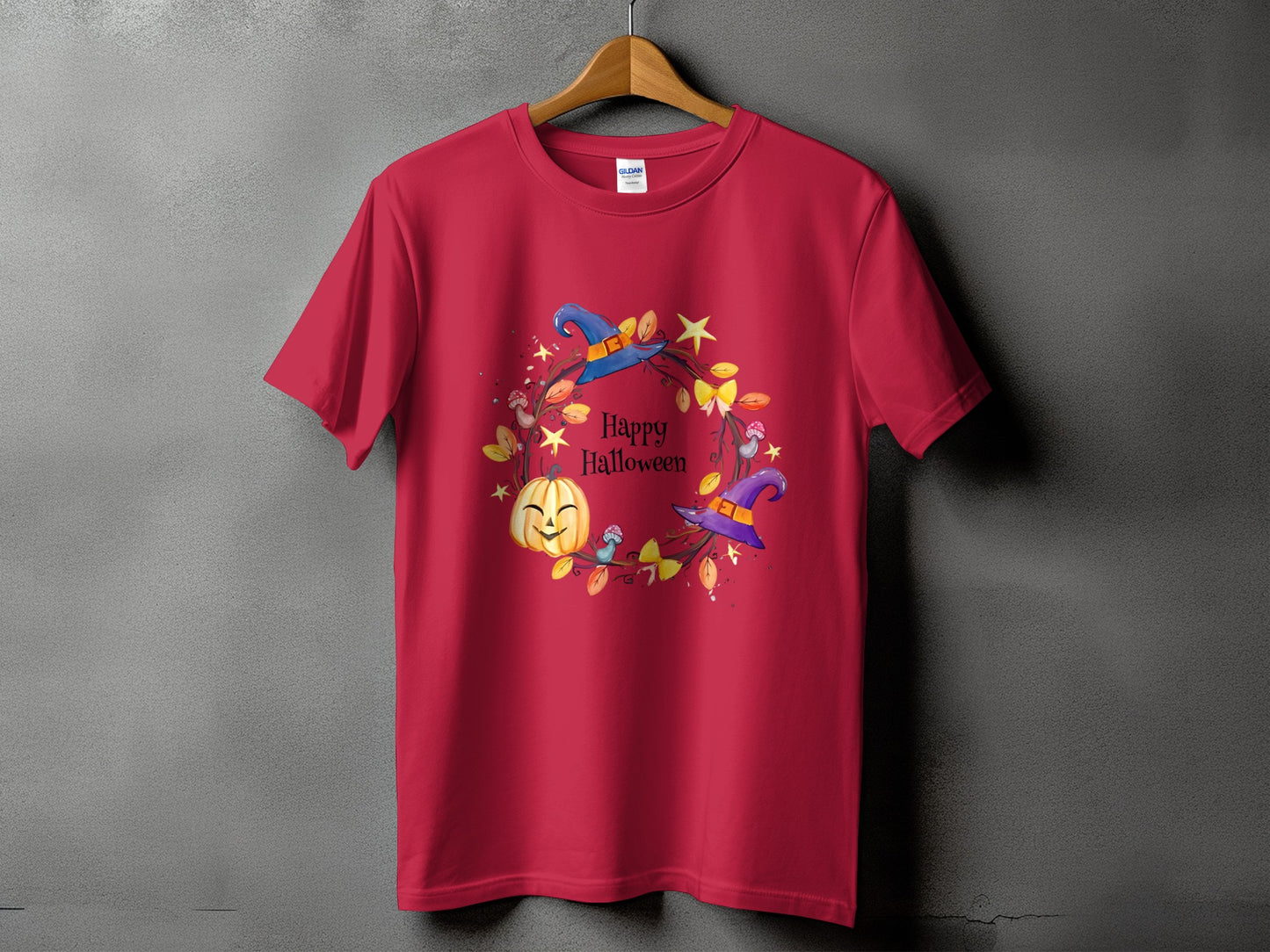 Red t-shirt with a Halloween graphic featuring a pumpkin, witches' hats, and text.