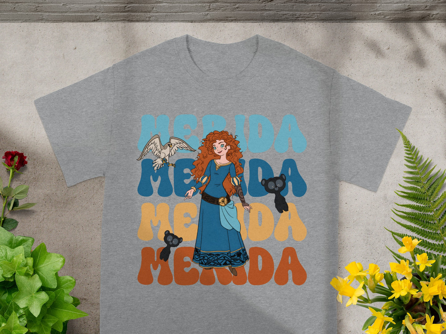 Merida with bird and bear on graphic t-shirt, text reads Merida.