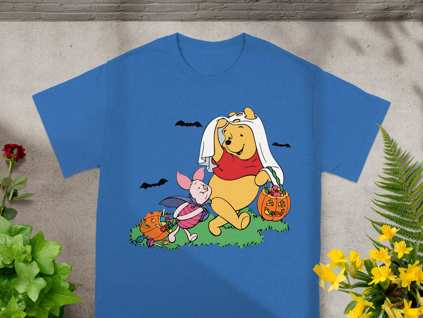 Winnie the Pooh and Piglet in Halloween costumes with candy and pumpkins.