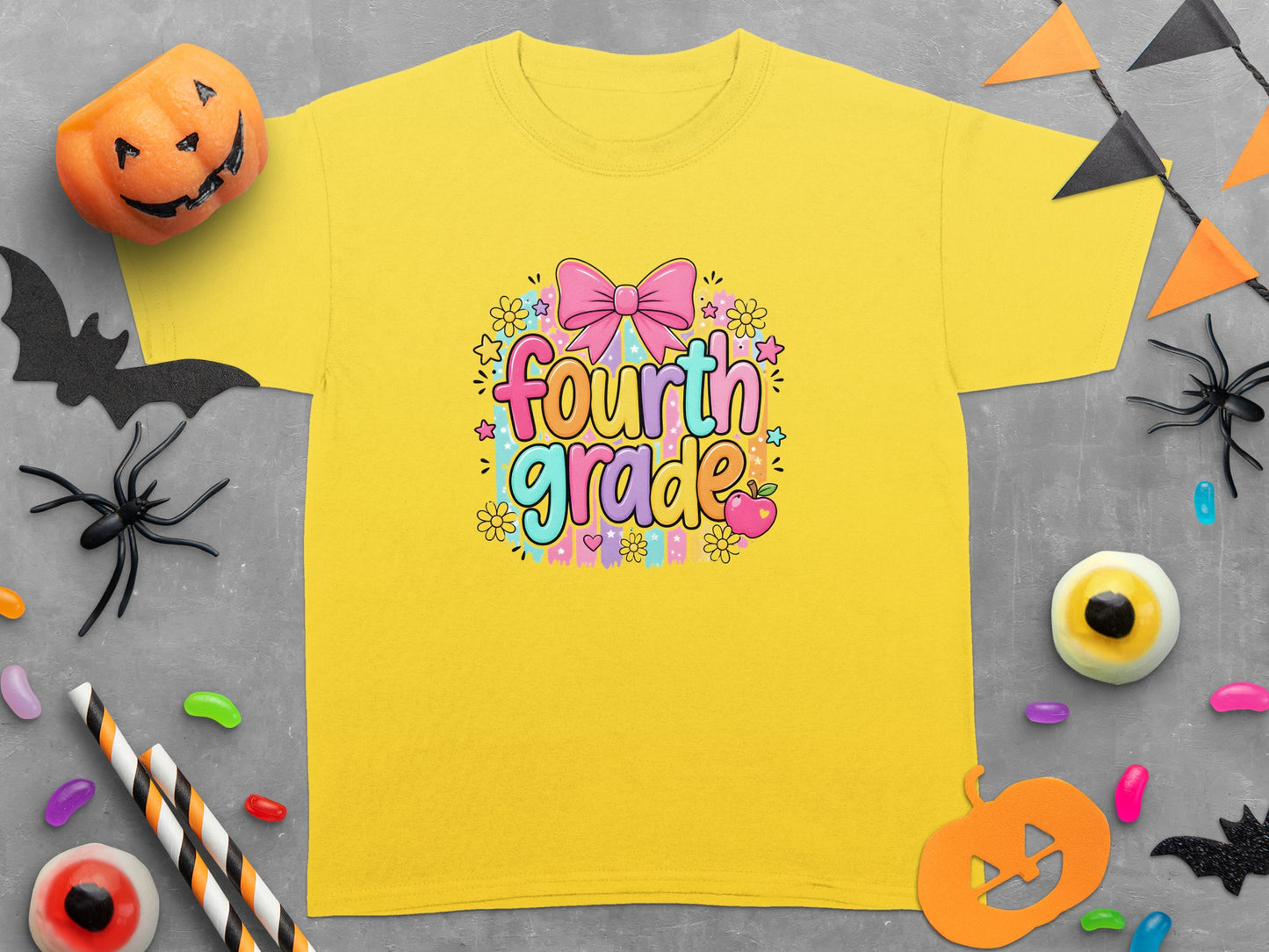 Yellow t-shirt with "Fourth Grade" text in colorful bubble letters and Halloween decor.