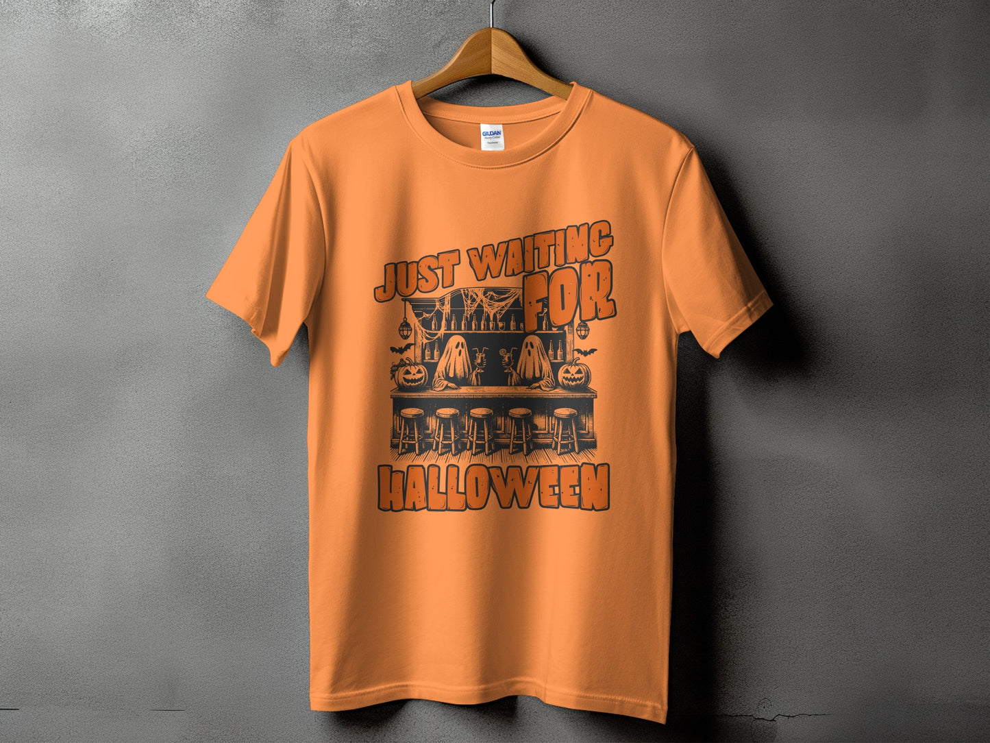 Orange t-shirt with "Just Waiting For Halloween" text and spooky bar scene design.