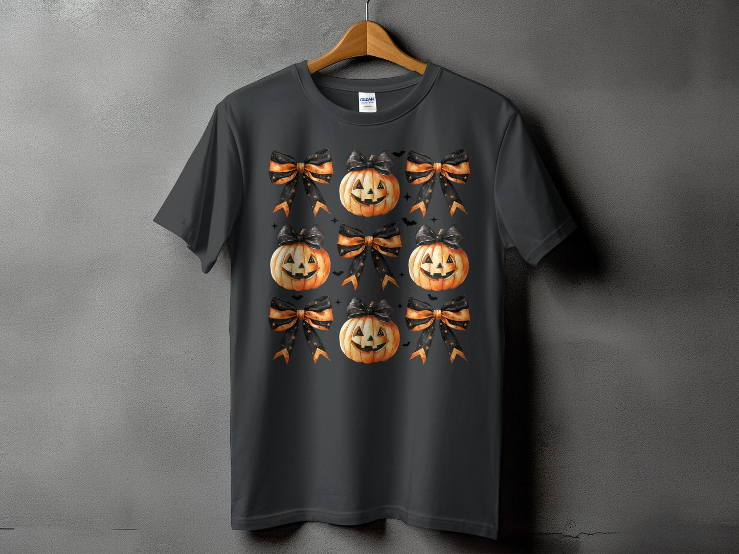 Dark grey t-shirt with a repeating pattern of jack-o'-lanterns and Halloween bows.