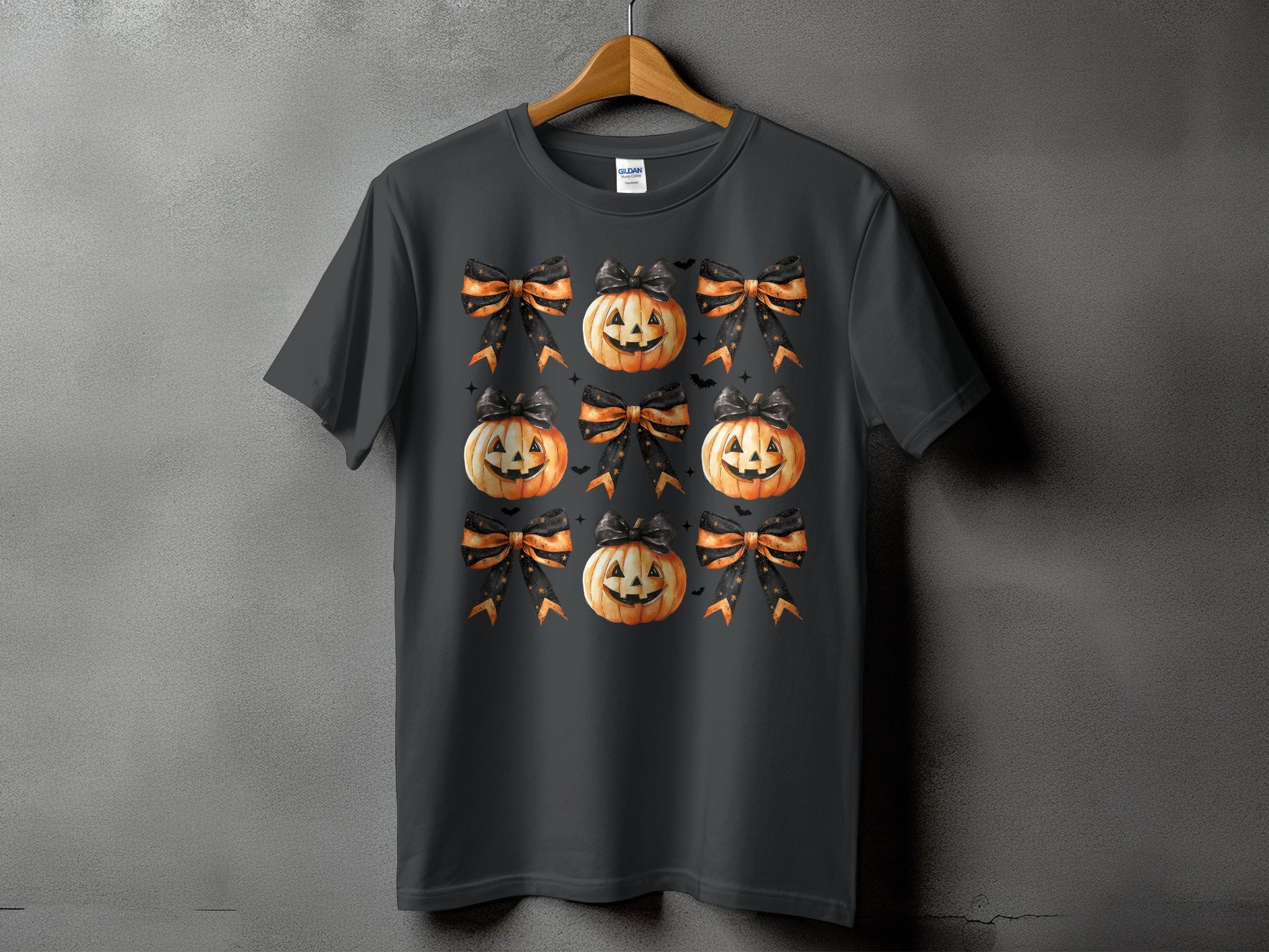Dark grey t-shirt with a repeating pattern of jack-o'-lanterns and Halloween bows.