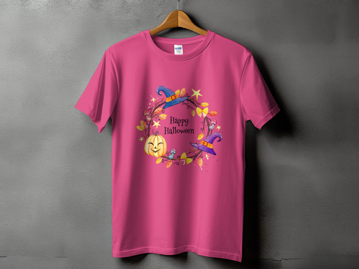 Pink t-shirt with a "Happy Halloween" wreath featuring a pumpkin and witch hats.