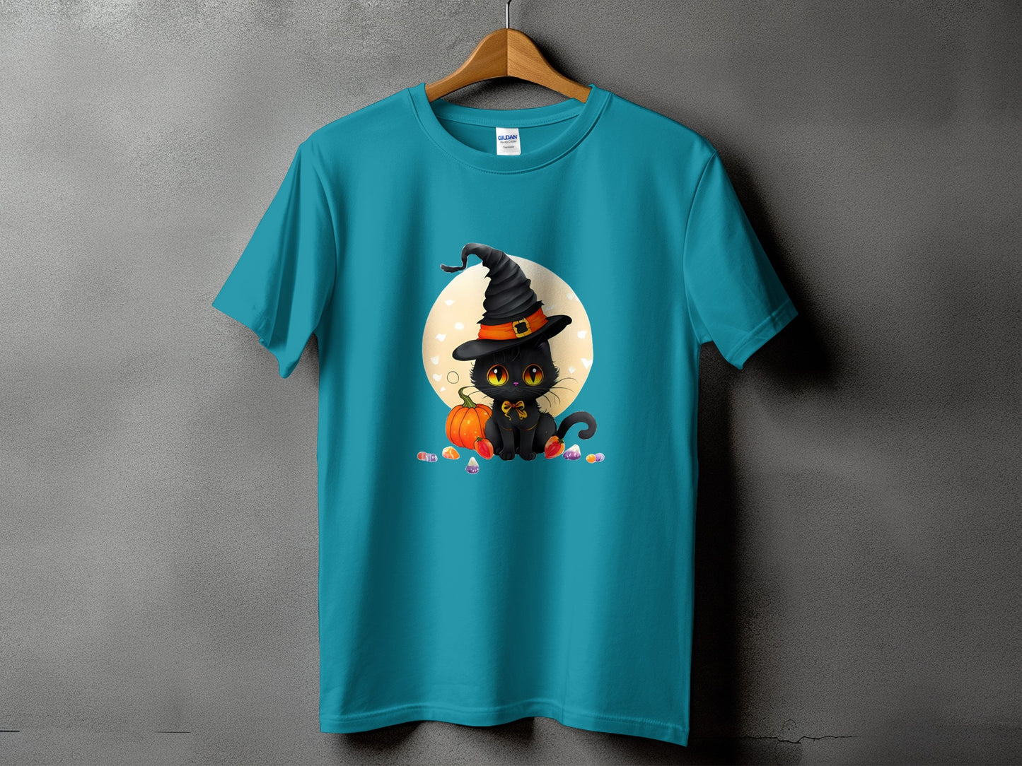 Teal t-shirt with cartoon black cat in witch hat, pumpkin, and candy.