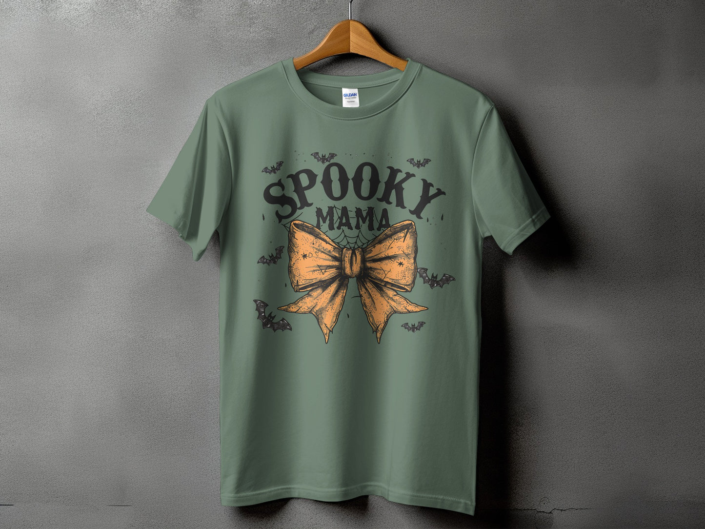 Green t-shirt with "Spooky Mama" text and orange bow graphic with bats.