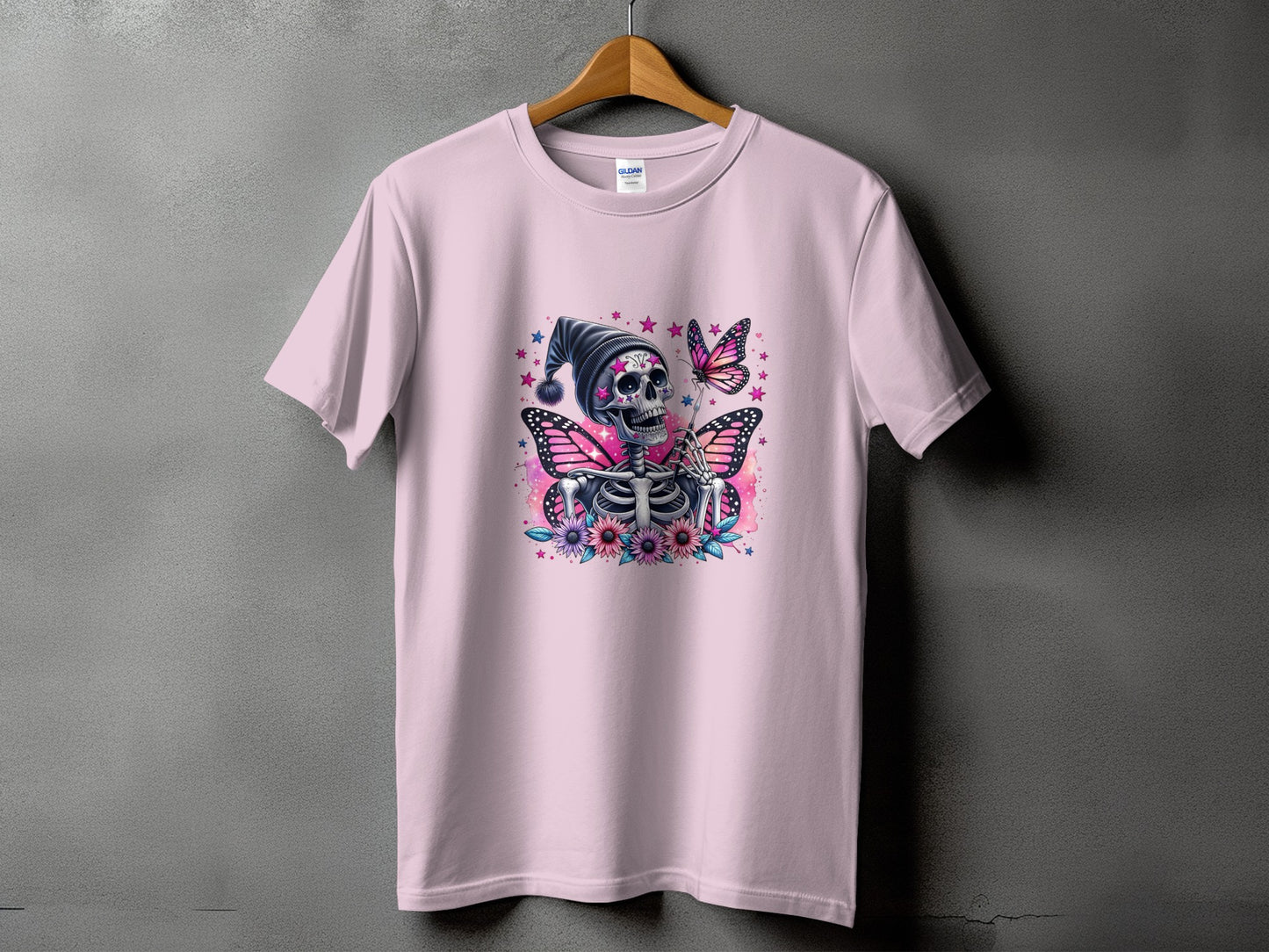 Pink t-shirt with skeleton, butterfly, flowers, and stars graphic.