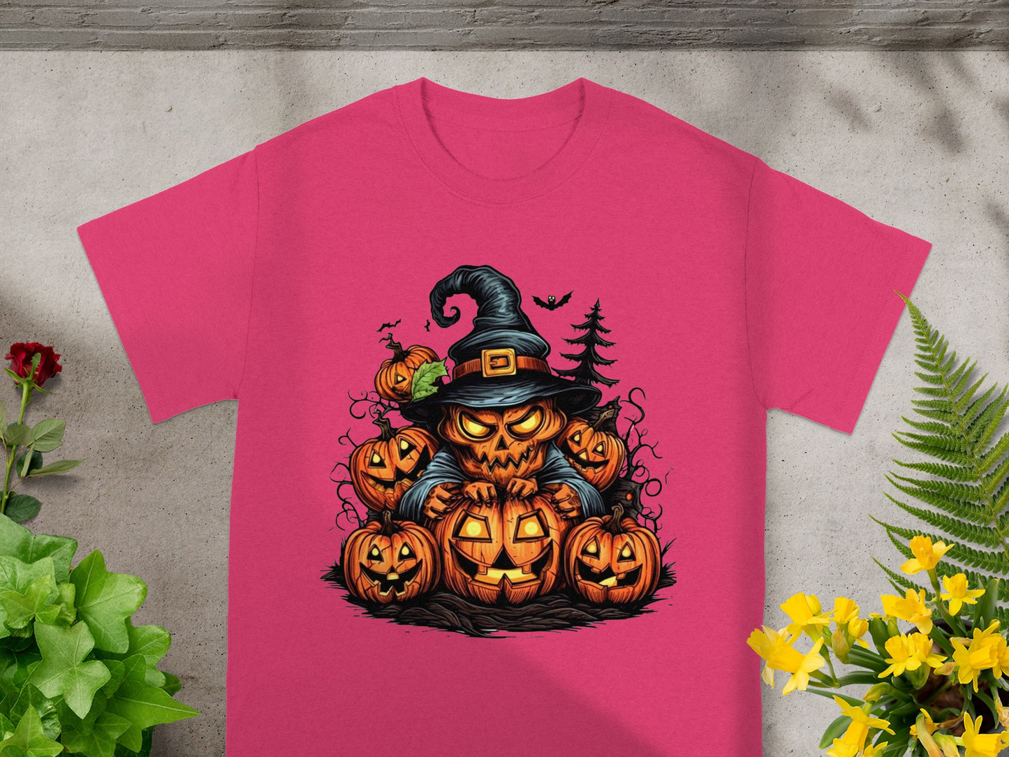 Pink t-shirt featuring a cartoon pumpkin scarecrow surrounded by jack-o'-lanterns.
