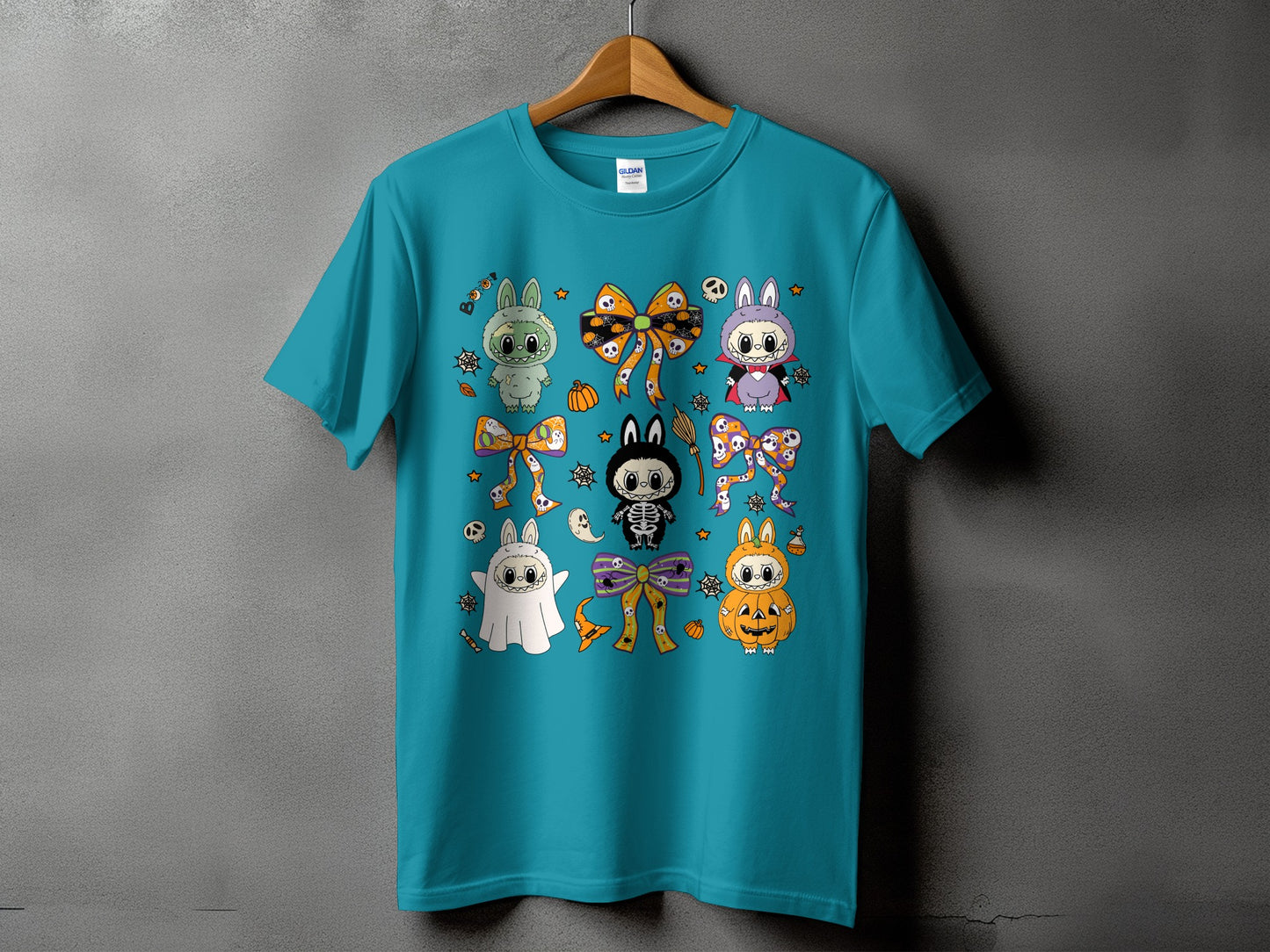 Teal t-shirt with Halloween-themed cartoon characters, bows, and candy graphics.
