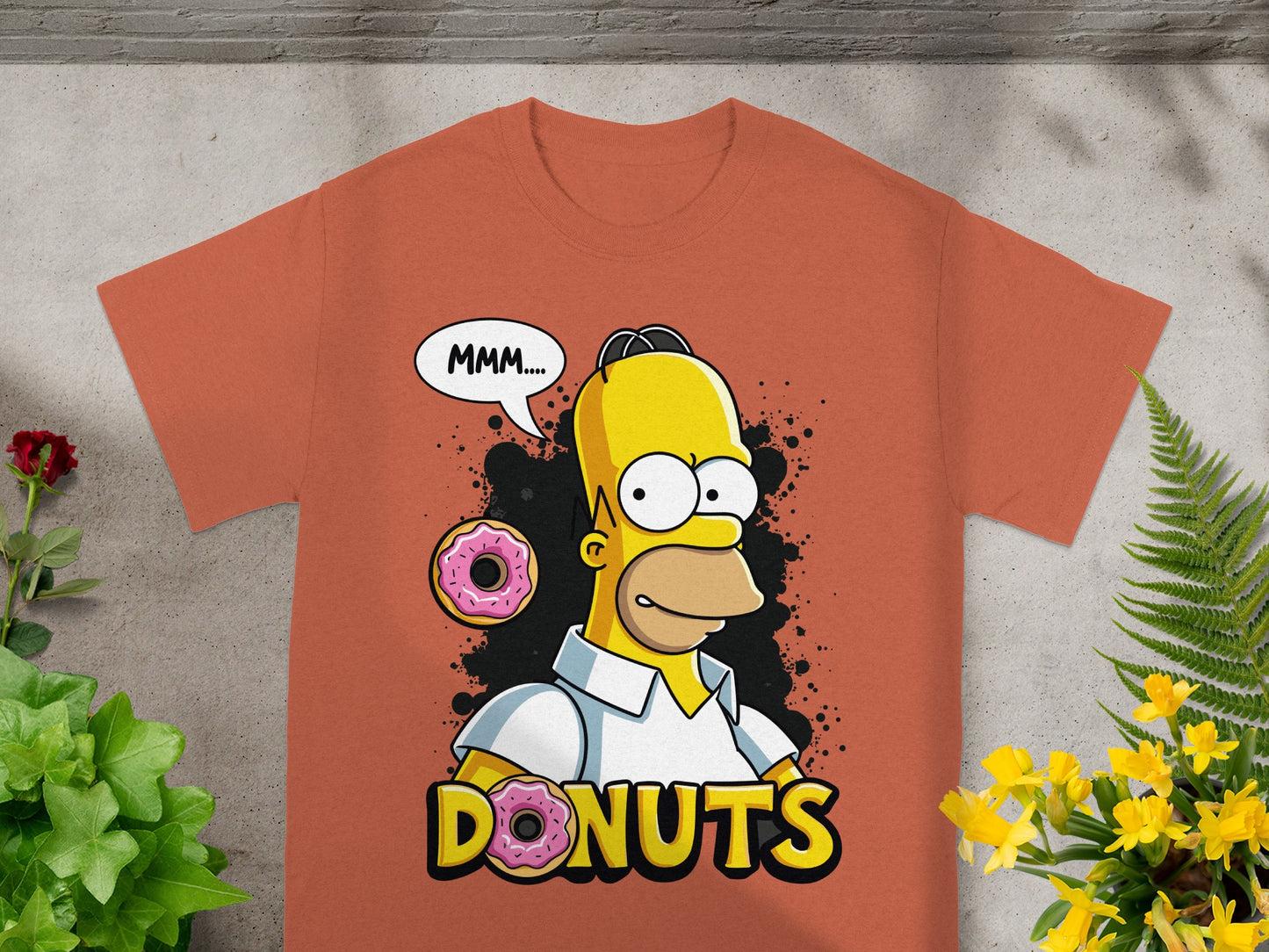 Homer Simpson saying "MMM..." with donuts and the word "DONUTS" on an orange t-shirt.